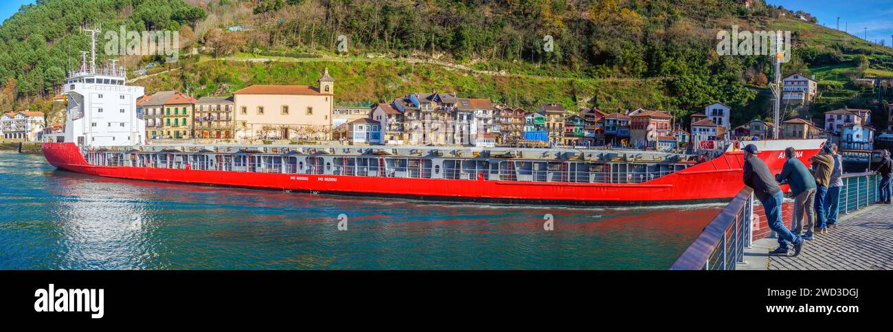 An oil tanker crossing in front of the fishing village of Pasajes de San Juan. Gipuzkoa, Basque country, Spain. Stock Photo