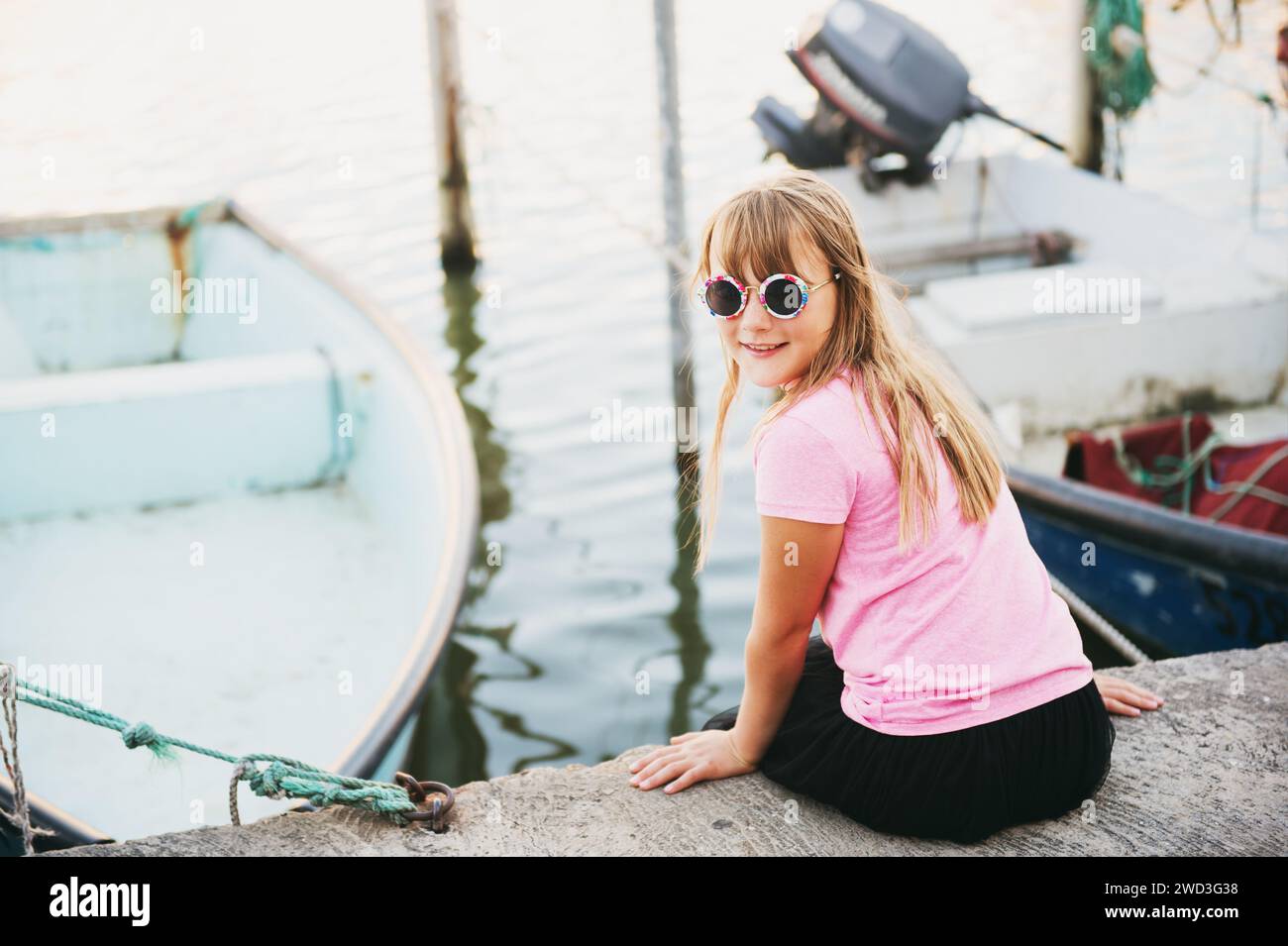 Kid girl resting in small port during summer vacation Stock Photo