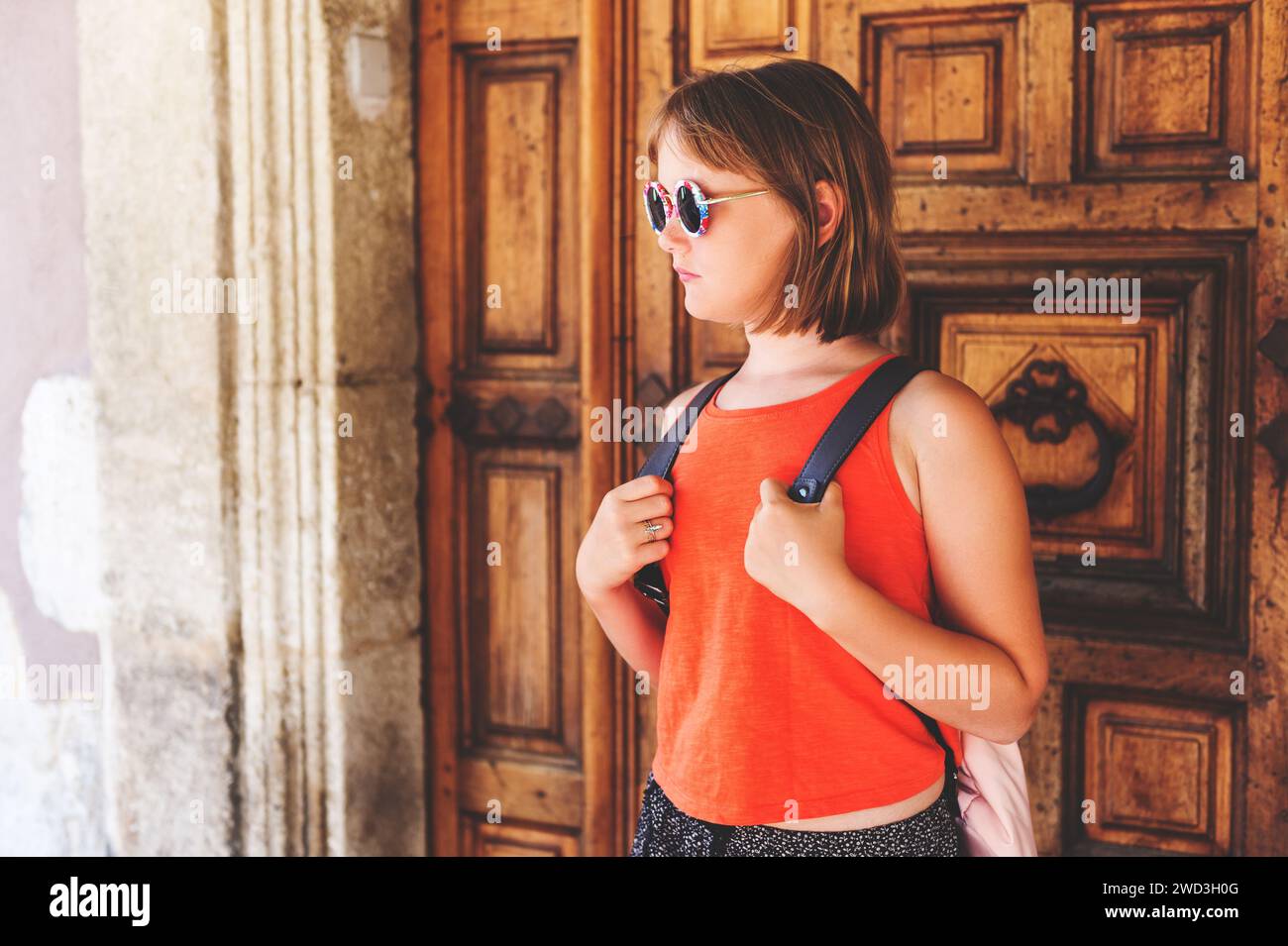 Funny little girl traveler walking on the streets of Provence, wearing backpack. Travel with kids, family vacation on south of France, image taken in Stock Photo