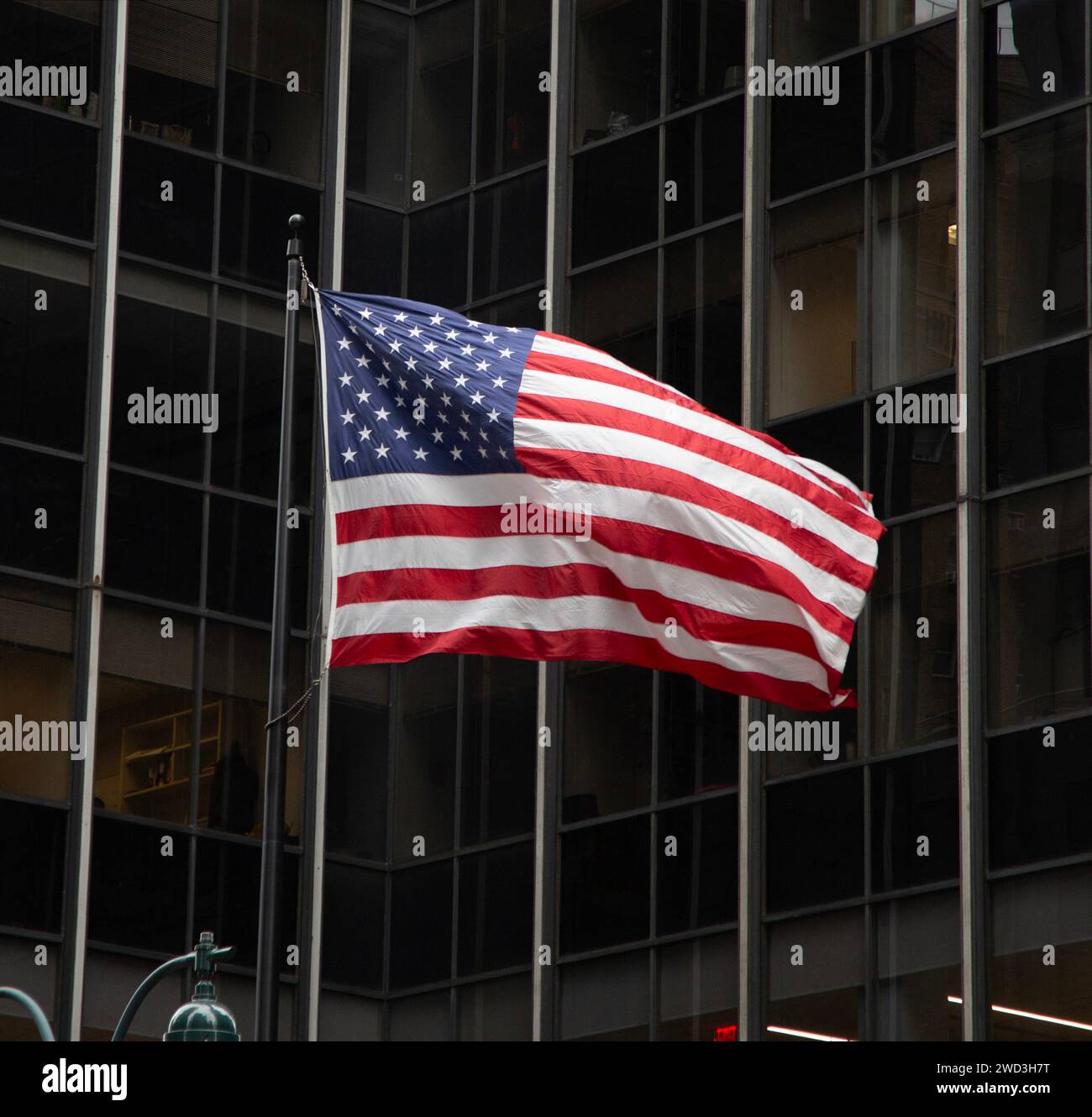 American Flag flying in the wind outside an office building in midtown Manhattan, New York City. Stock Photo