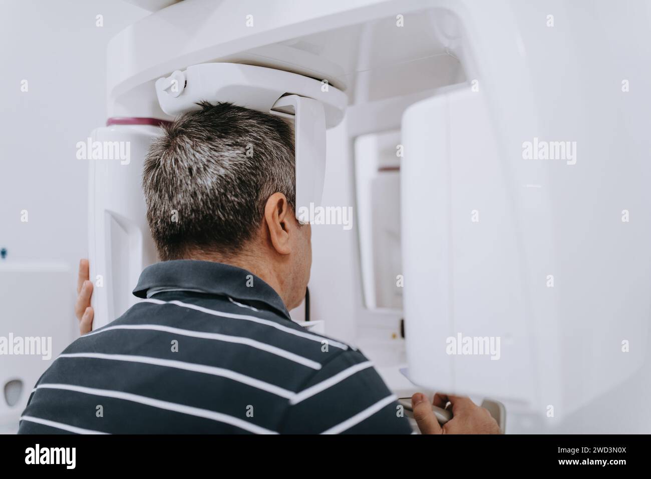 Elderly man in a modern dental clinic undergoing a 3D teeth scan for
