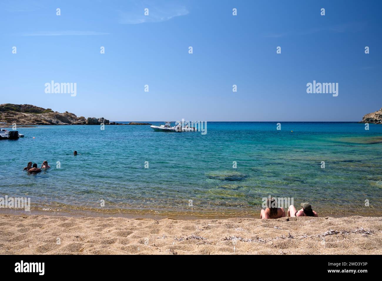 Ios, Greece - September 15, 2023 : View of young tourists enjoying the incredible sandy and turquoise beach of Pikri Nero in Ios Greece Stock Photo