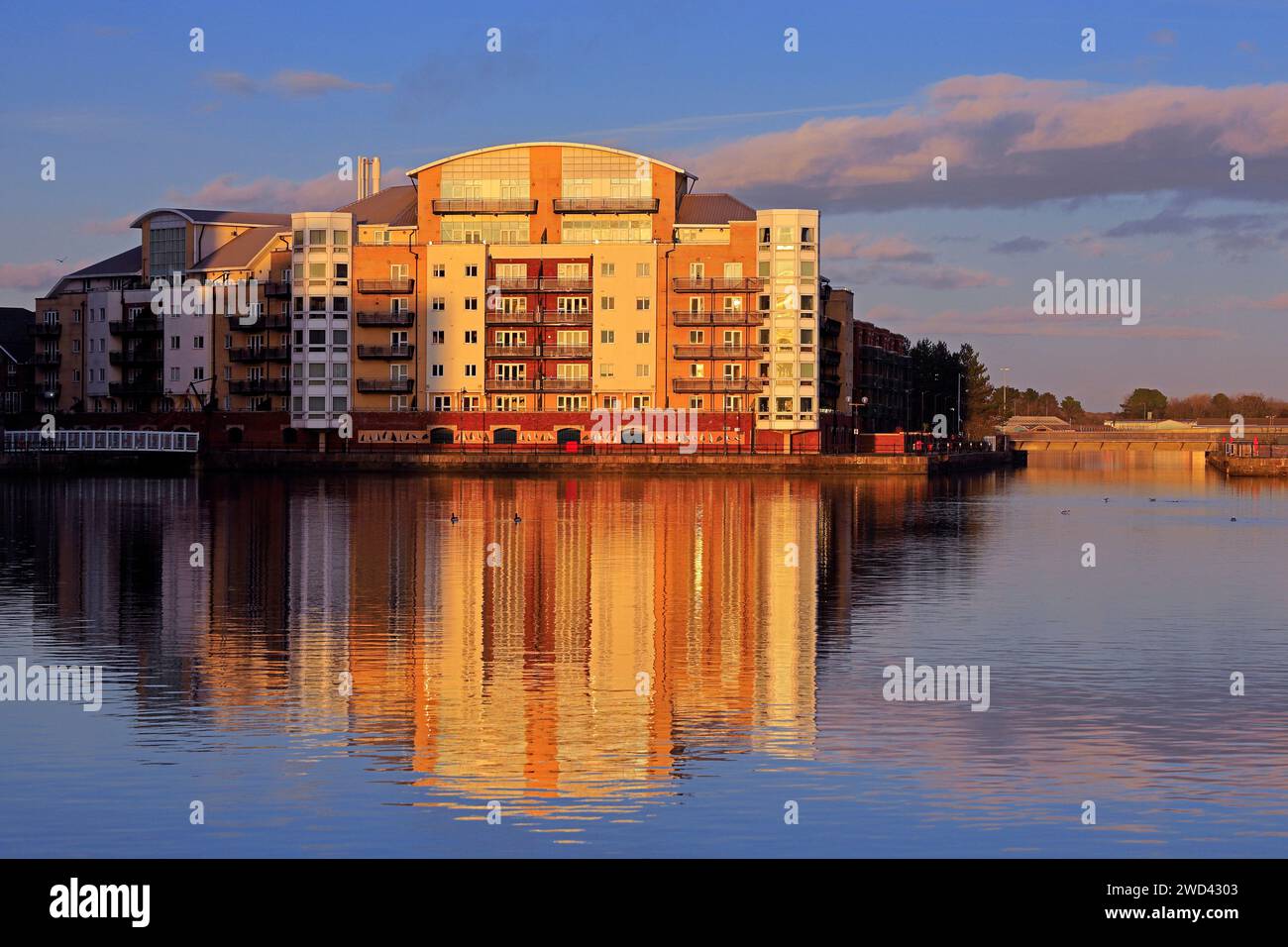 Reflections of a block of flats in early evening light near sunset, Roath Basin, Cardiff Bay