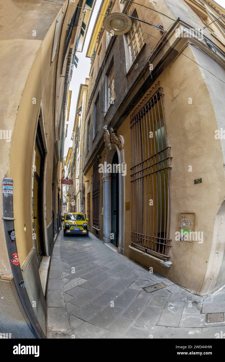 GENOA, ITALY - MARCH 20, 2021: Incredible car traffic on the super narrow streets of the historic city center. Typical for the Italian cities. Stock Photo