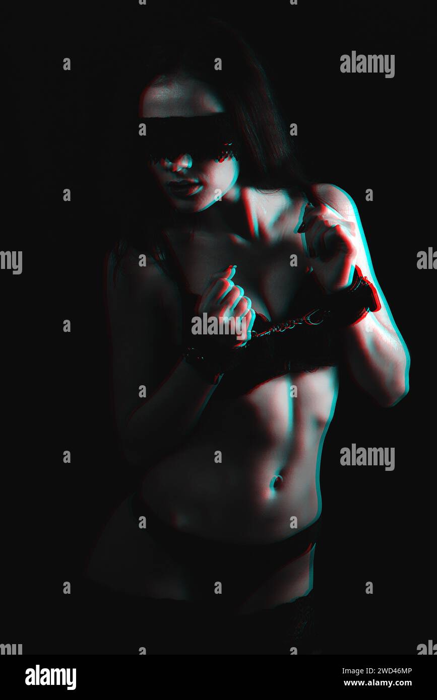 sexy slave girl with big Breasts in lingerie in leather handcuffs and silk  bandage on her face with glitch effect Stock Photo - Alamy