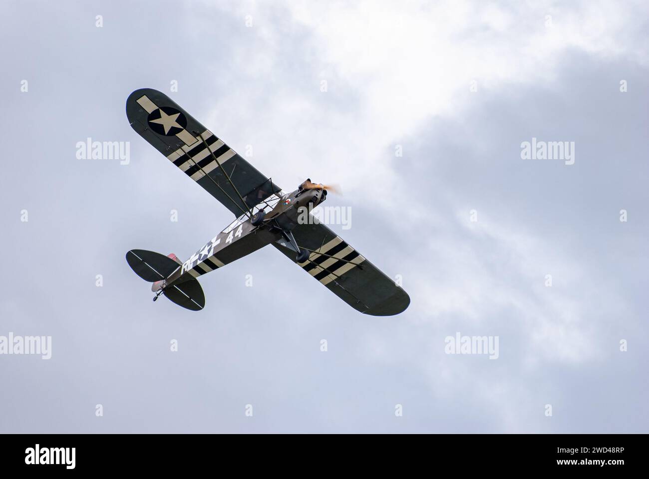 WW2 Plane USAF Piper Cub flying in the clouds Stock Photo