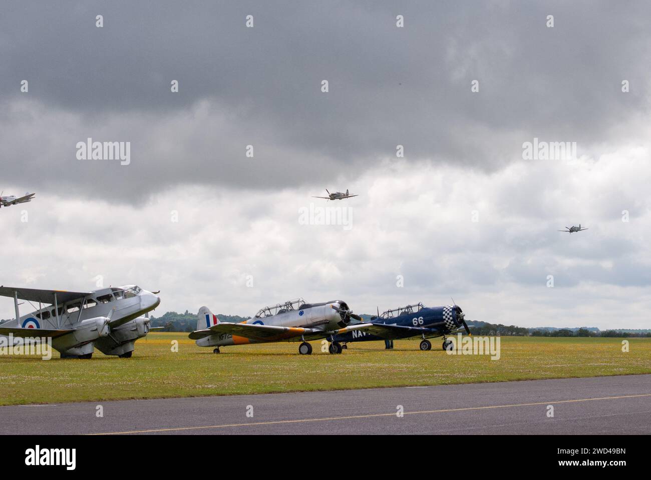 Spitfires dogfight flying low during airshow of vintage aircraft. Stock Photo