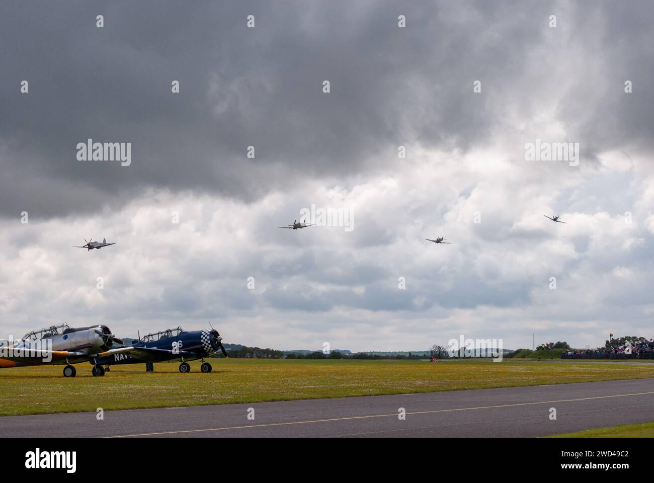 Spitfires dogfight flying low during airshow of vintage aircraft. Stock Photo