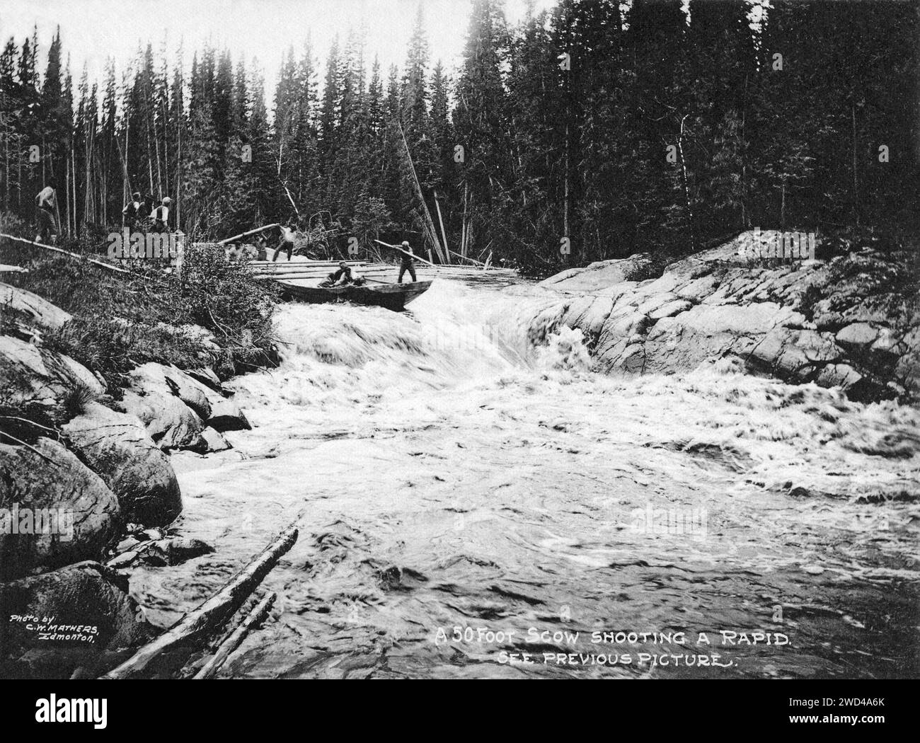 A 1901 photograph of a flat-bottomed cargo scow, being run down through rapids on a side channel of the Slave River in Alberta/Northwest Territories, taken by C W Mathers on an expedition to the far north of Canada and published in his book ‘The Far North’. Mathers captioned this photograph: A 50 foot scow shooting a rapid. See previous picture [Alamy image: 2WD4A6F]. Stock Photo