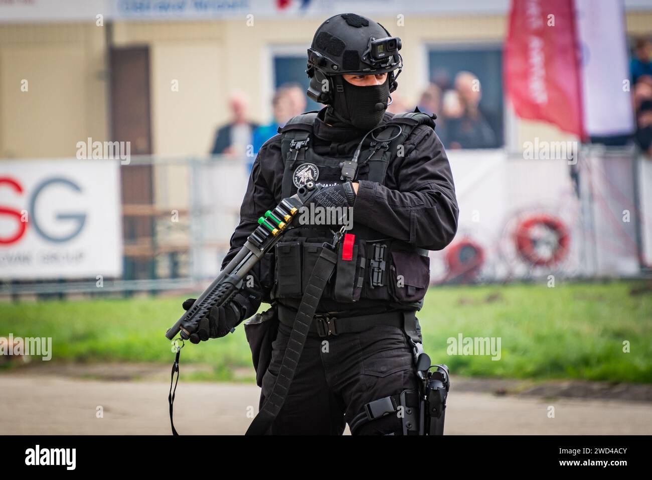 Man with shotgun. Tactical SWAT officer from the Czech border force standing in full body armour holding a shotgun at NATO days airshow. Stock Photo