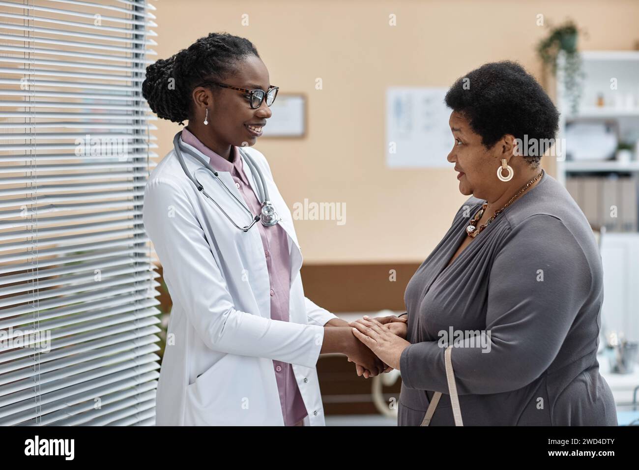 Doctor welcoming senior female hi-res stock photography and images - Alamy