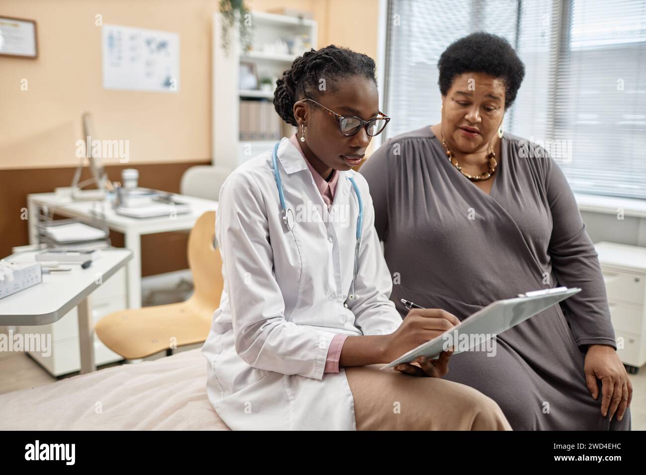 Patient Writing Woman Doctor Writing in Patients Card Stock Photo - Alamy