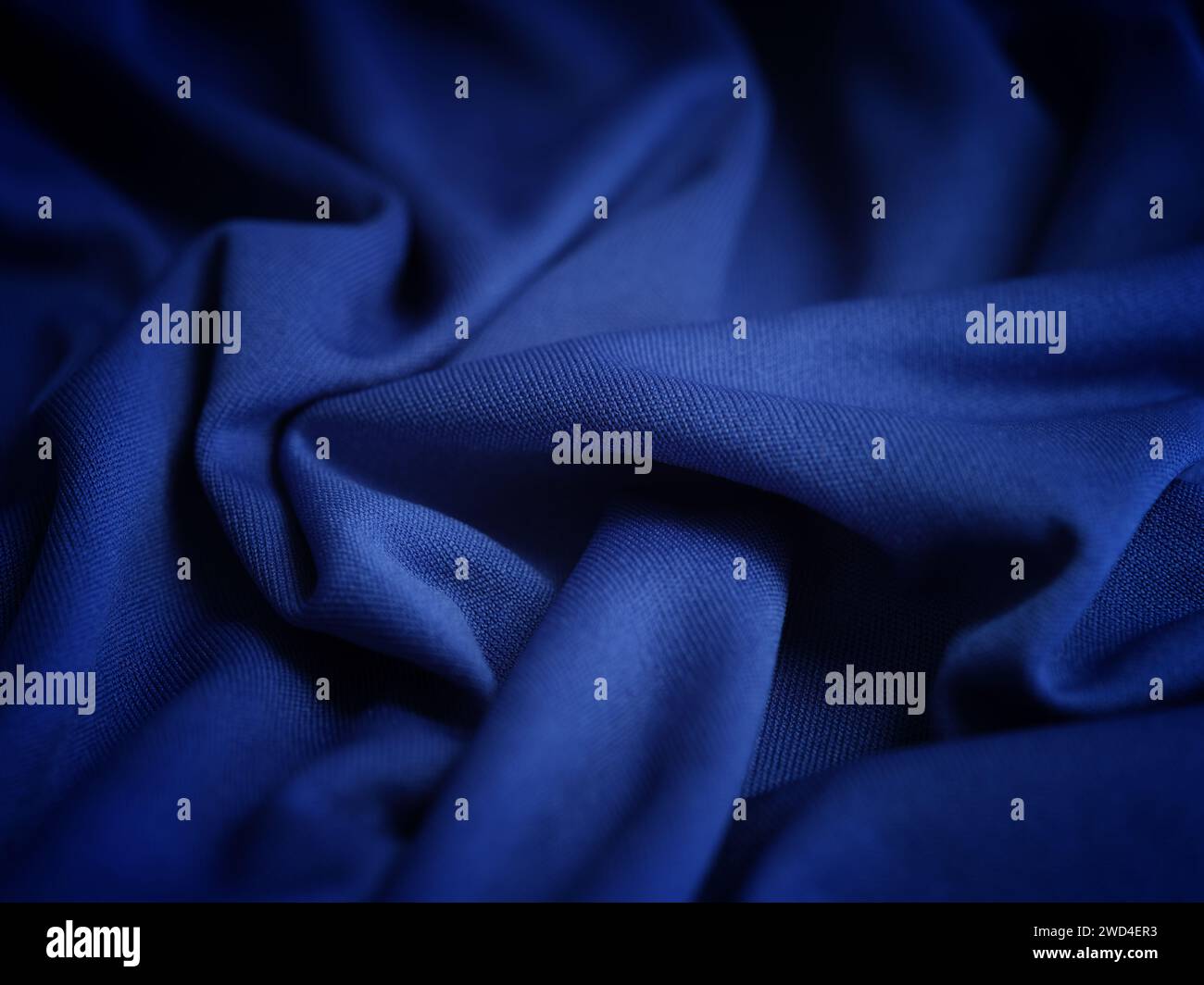 A crumpled dark blue fabric background. Close up. Stock Photo