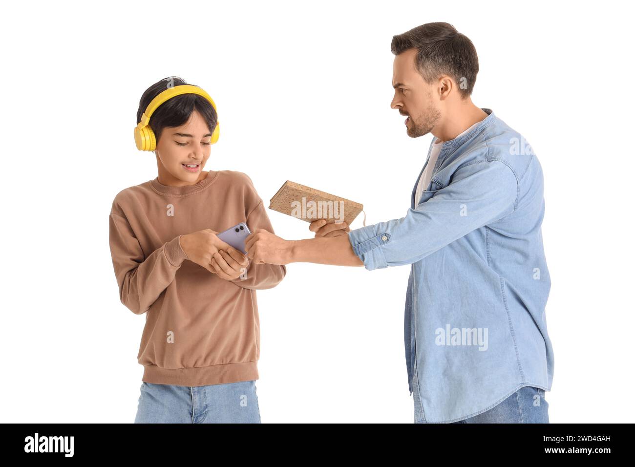 Angry father with book taking mobile phone away from his teenage son on
