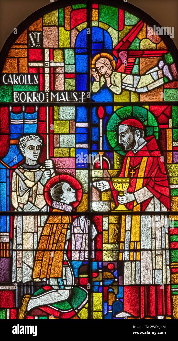 BERN, SWITZERLAND - JUNY 27, 2022: The St. Charles Borromeo on the stained glass in the church Dreifaltigkeitskirche by A. Schweri (1938). Stock Photo