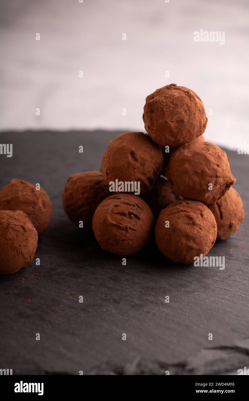 Photography featuring of homemade dark chocolate truffles, adorned with cocoa powder. This visually appealing arrangement captures the richness of coc Stock Photo