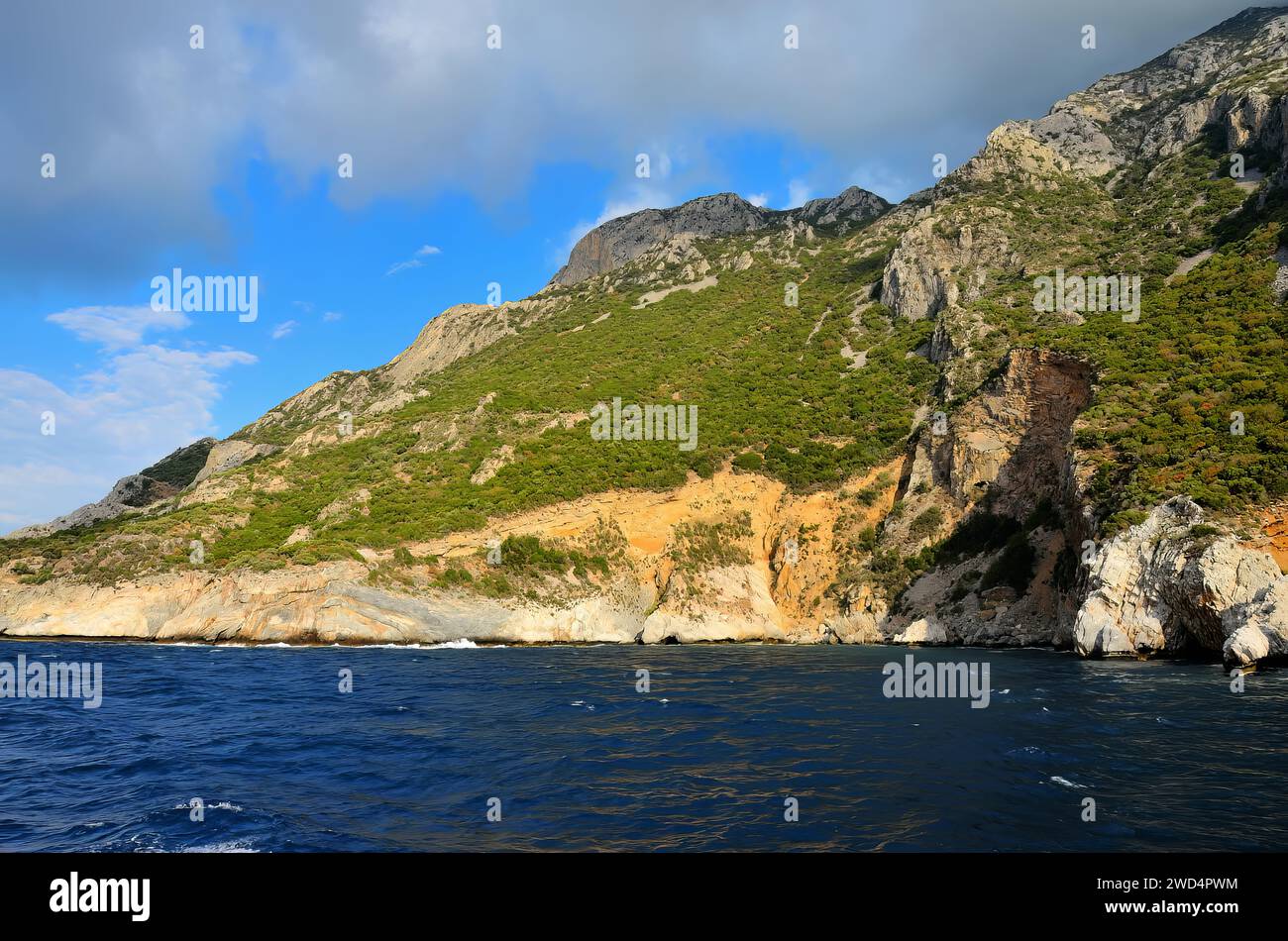 A stunning daytime view of ocean cliffs overlooking rocks and the sparkling water below Stock Photo