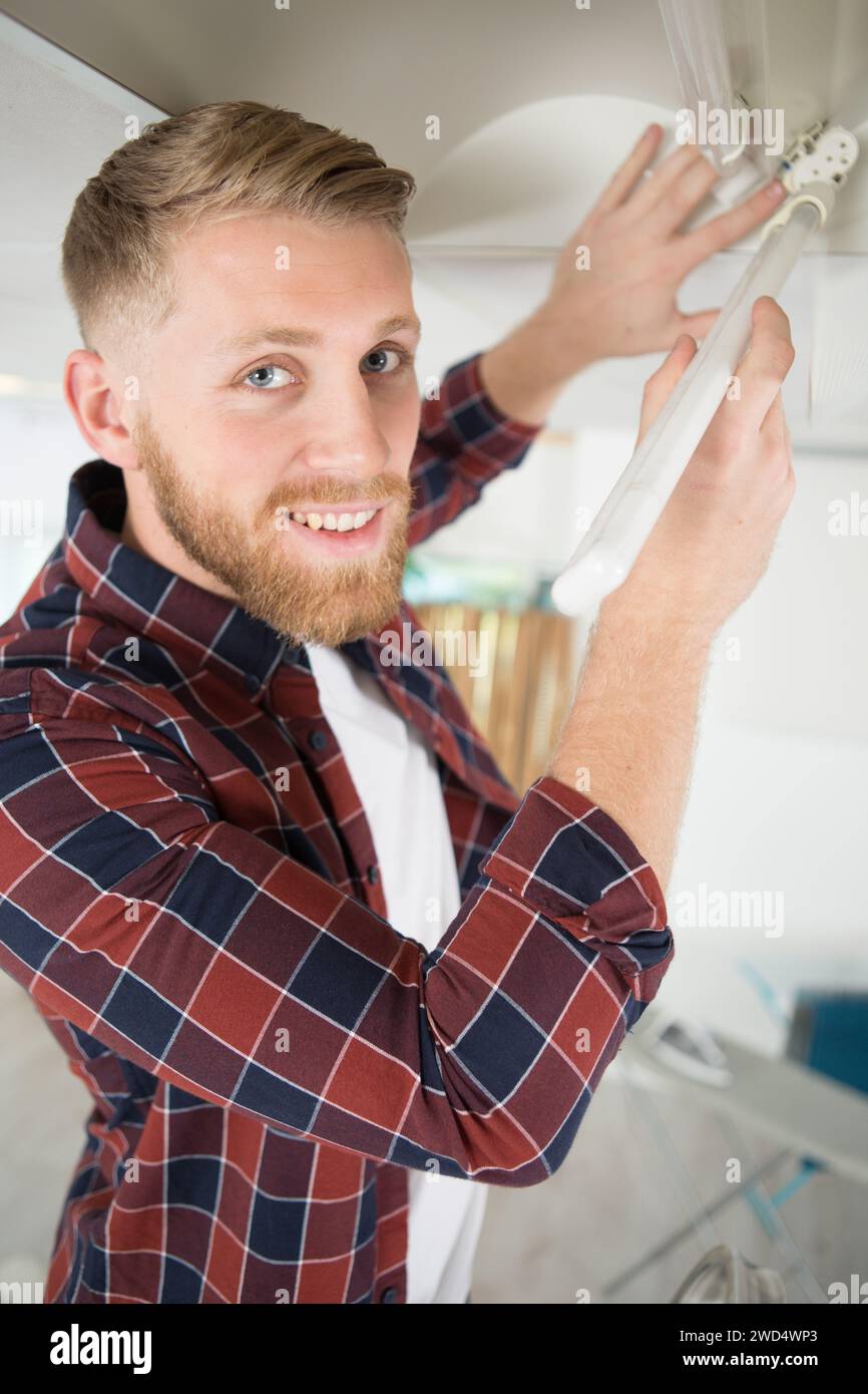 man replacing the light bulb on the ceiling Stock Photo - Alamy