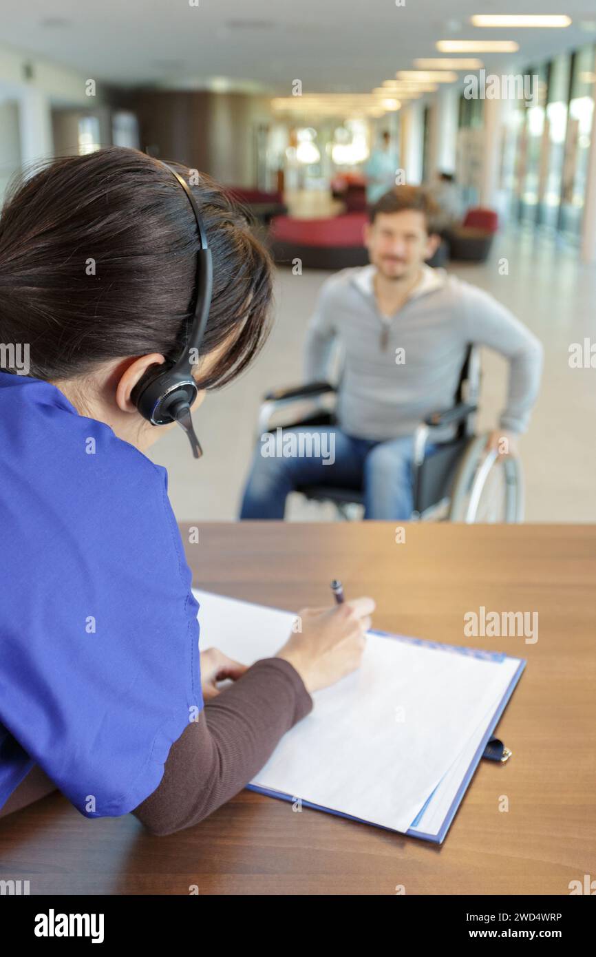disabled patient at hospital reception waiting for receptionist Stock ...