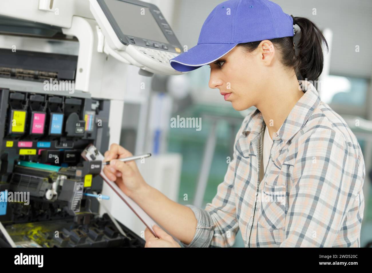 young female technician fixing a printer Stock Photo