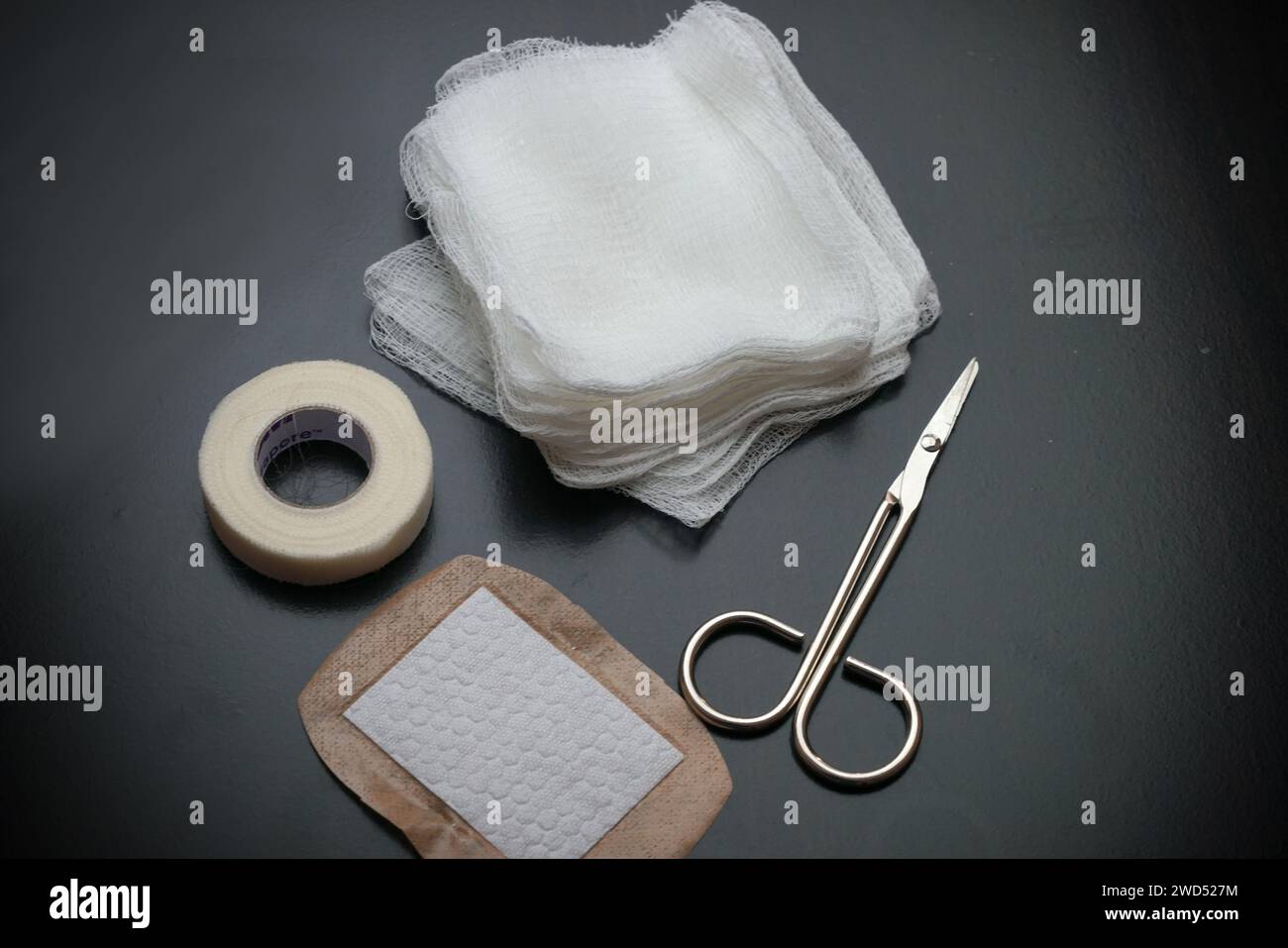 The Gauze pads bandage and scissors used to control bleeding for first