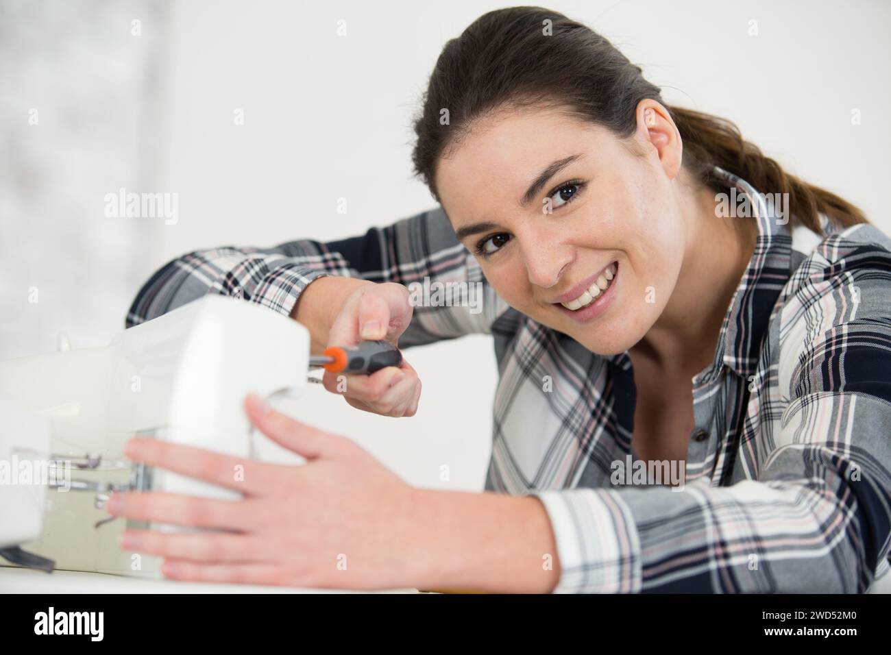 Happy woman repairing machine hi-res stock photography and images - Alamy