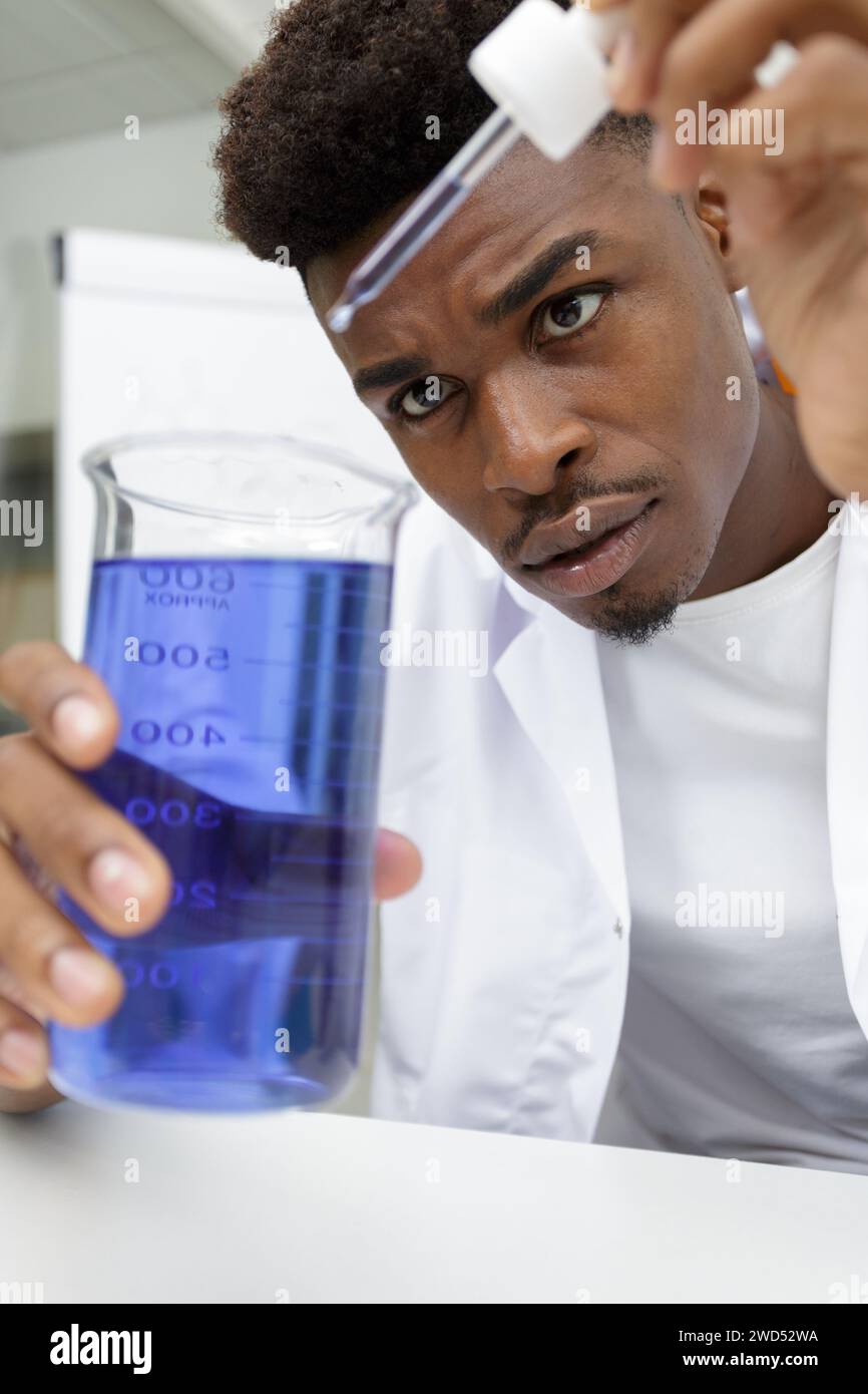 young man scientist using auto-pipette with flask in laboratory Stock Photo