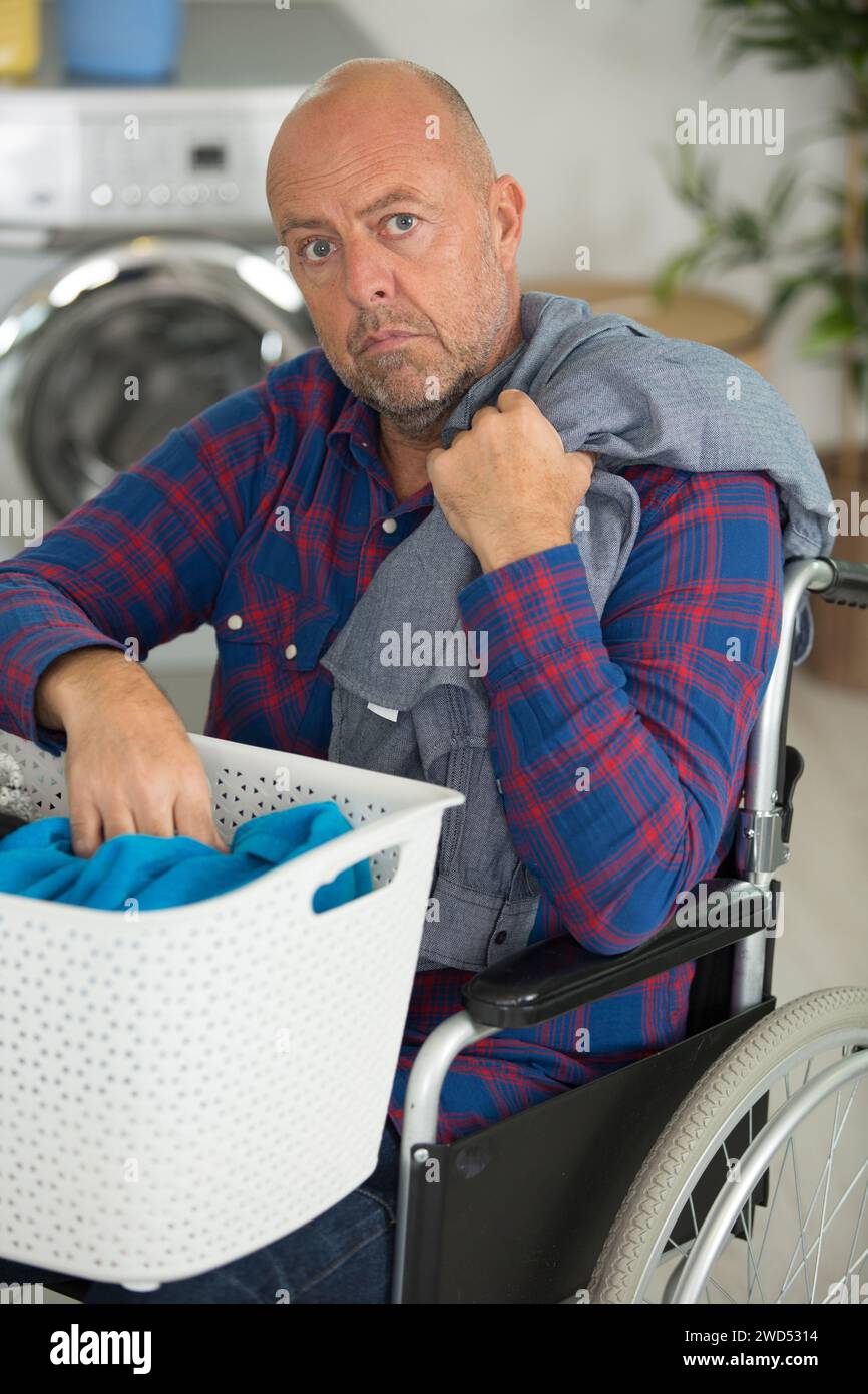 disabled man doing laundry Stock Photo