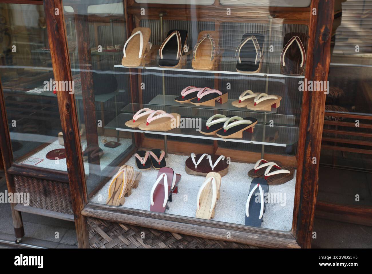 A display of geta or traditional Japanese sandals in a glass cabinet in an ancient shoe store in Yamatooji Street in Gion, Kyoto, Japan. Stock Photo