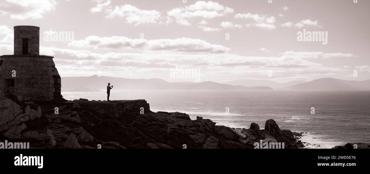 Captured in sepia tones, a solitary figure stands contemplatively at ...