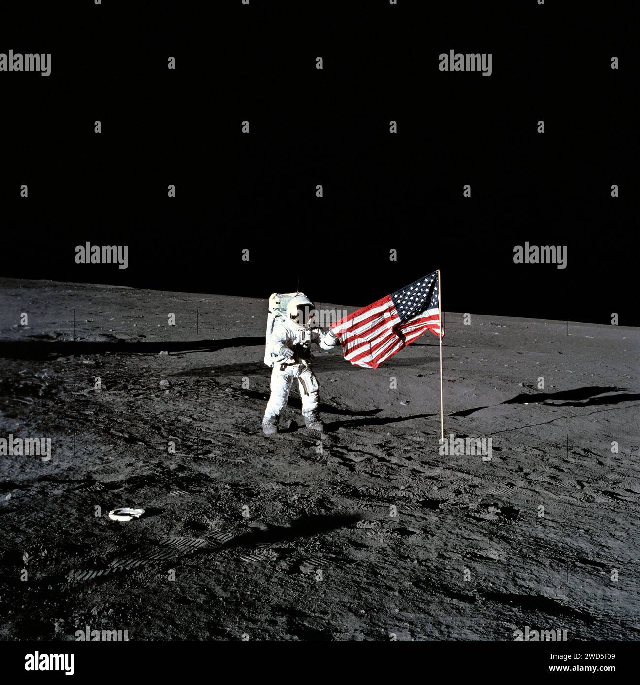 American astronaut Charles Conrad Jr., Apollo 12 commander, standing beside American flag after it was unfurled on lunar surface during  first extravehicular activity, NASA , November 19, 1969 Stock Photo