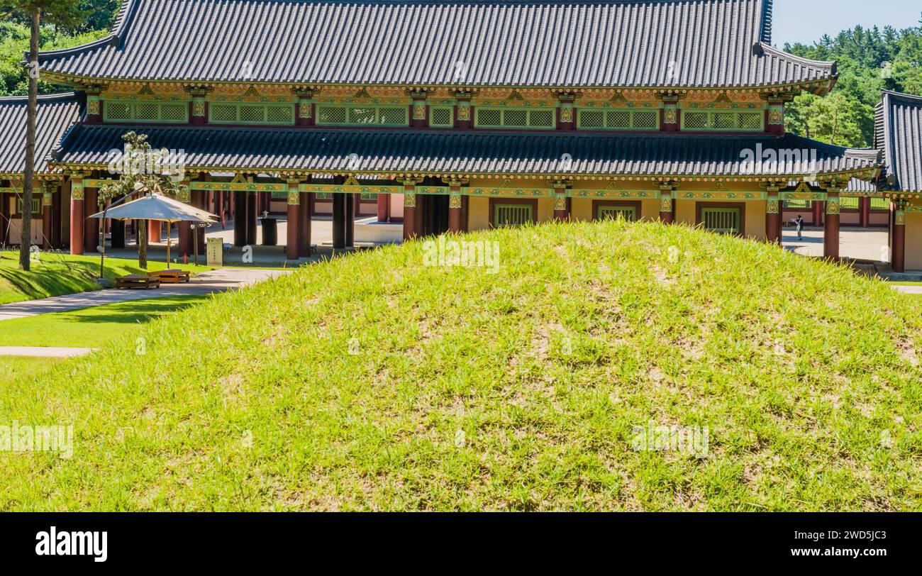 Closeup of burial mound in front of oriental building with ceramic tile ...