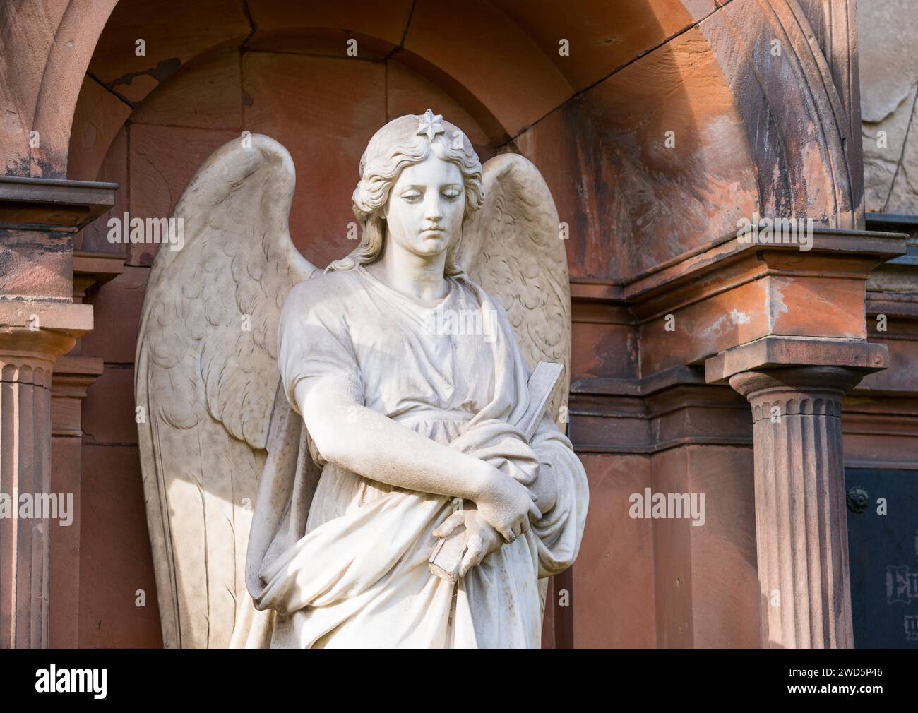 Female white angel figure, with star on the top of her head, angel statue with pensive facial expression and staff in her hand, historical tomb Stock Photo