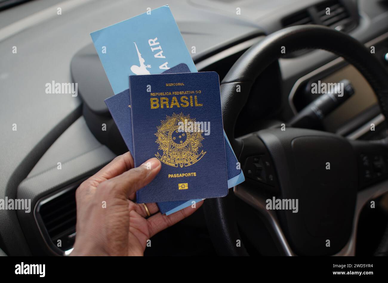 Hand holding the Brazilian passport in a closeup, symbolizing the
