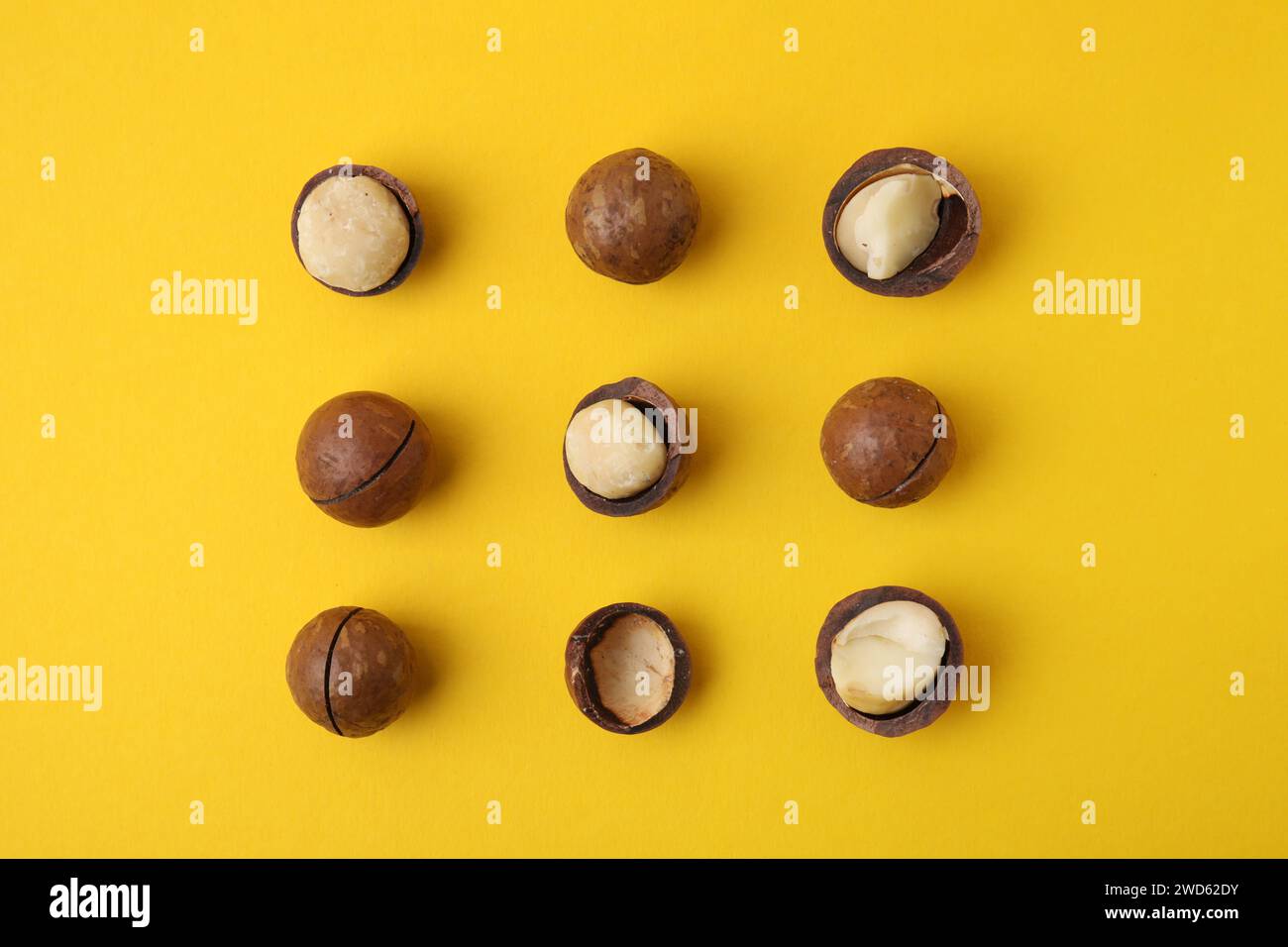 Tasty Macadamia nuts on yellow background, flat lay Stock Photo