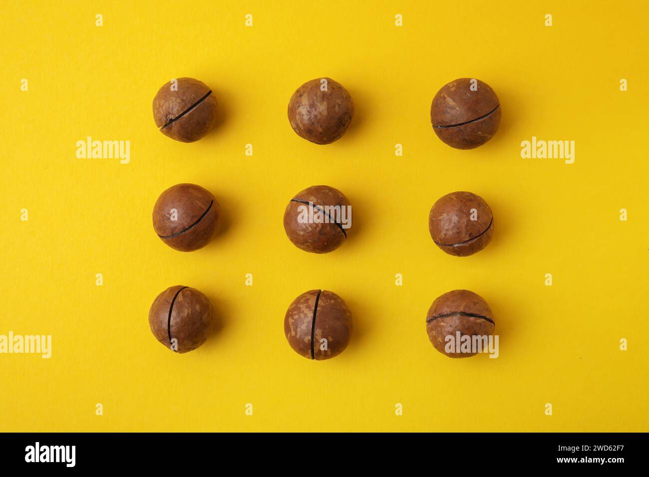Tasty Macadamia nuts on yellow background, flat lay Stock Photo