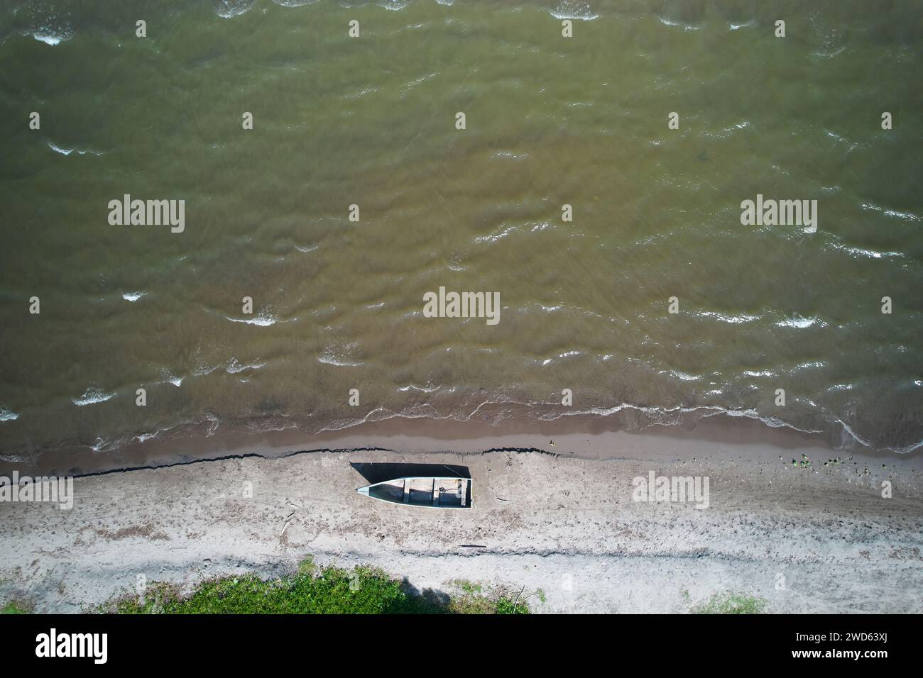 Row old boat in shore above top drone view next to green water Stock Photo
