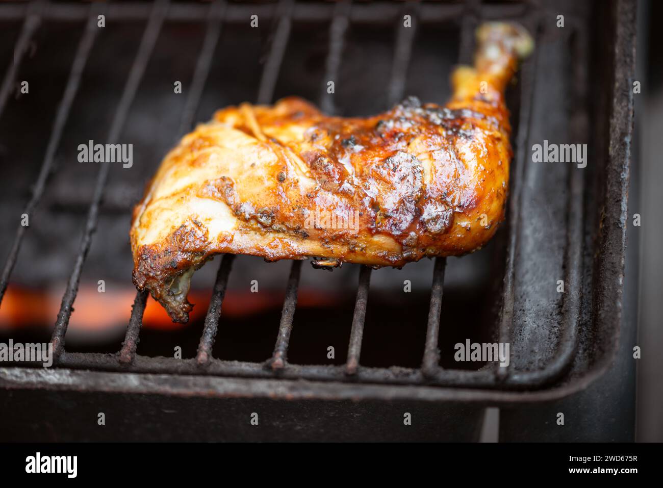 Barbeque pit chicken leg and thigh covered in BBQ sauce and spices and homemade spicy sauce flavourful Caribbean taste Stock Photo