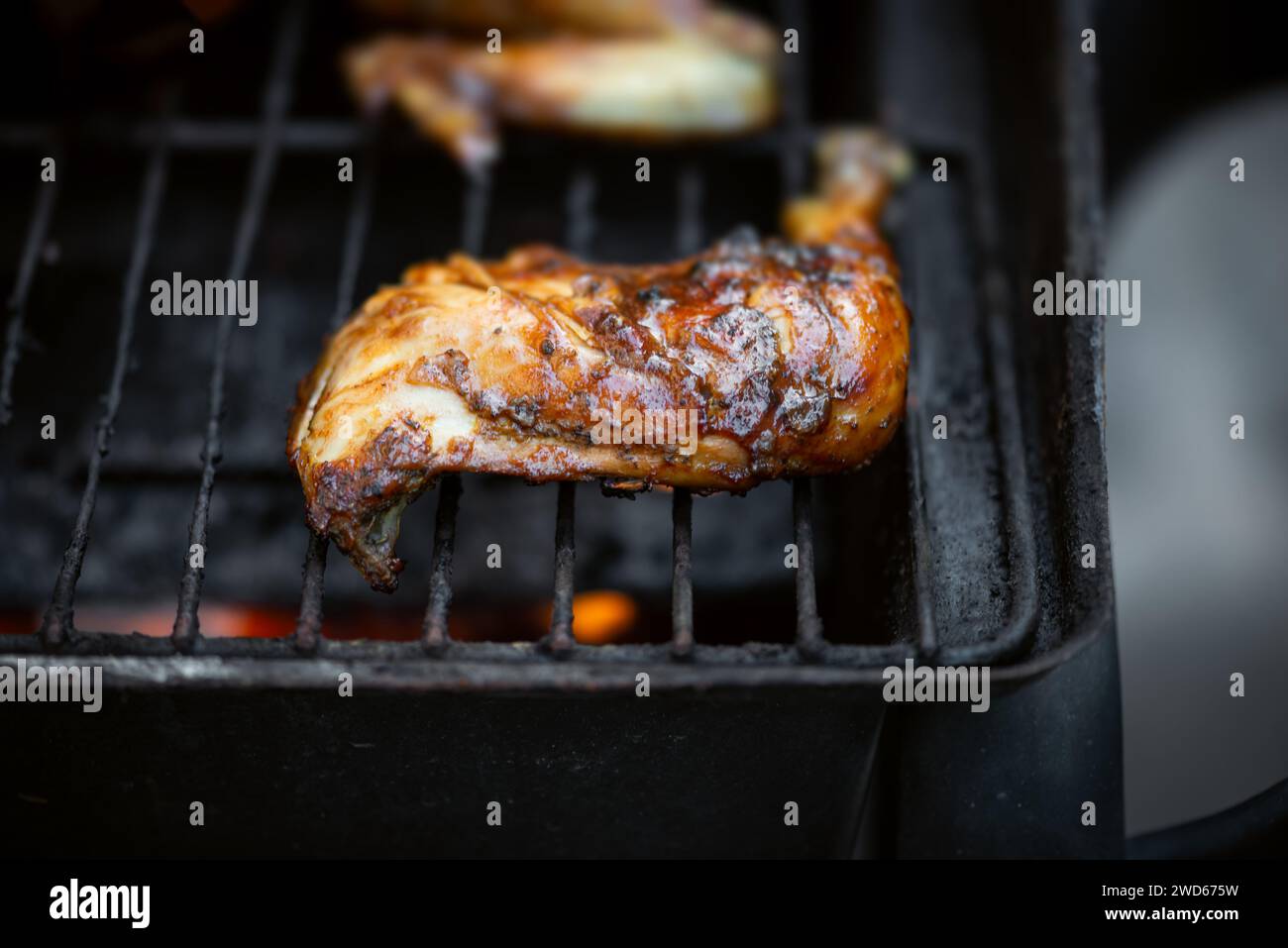 Barbeque pit chicken leg and thigh covered in BBQ sauce and spices and homemade spicy sauce flavorful Caribbean taste Stock Photo