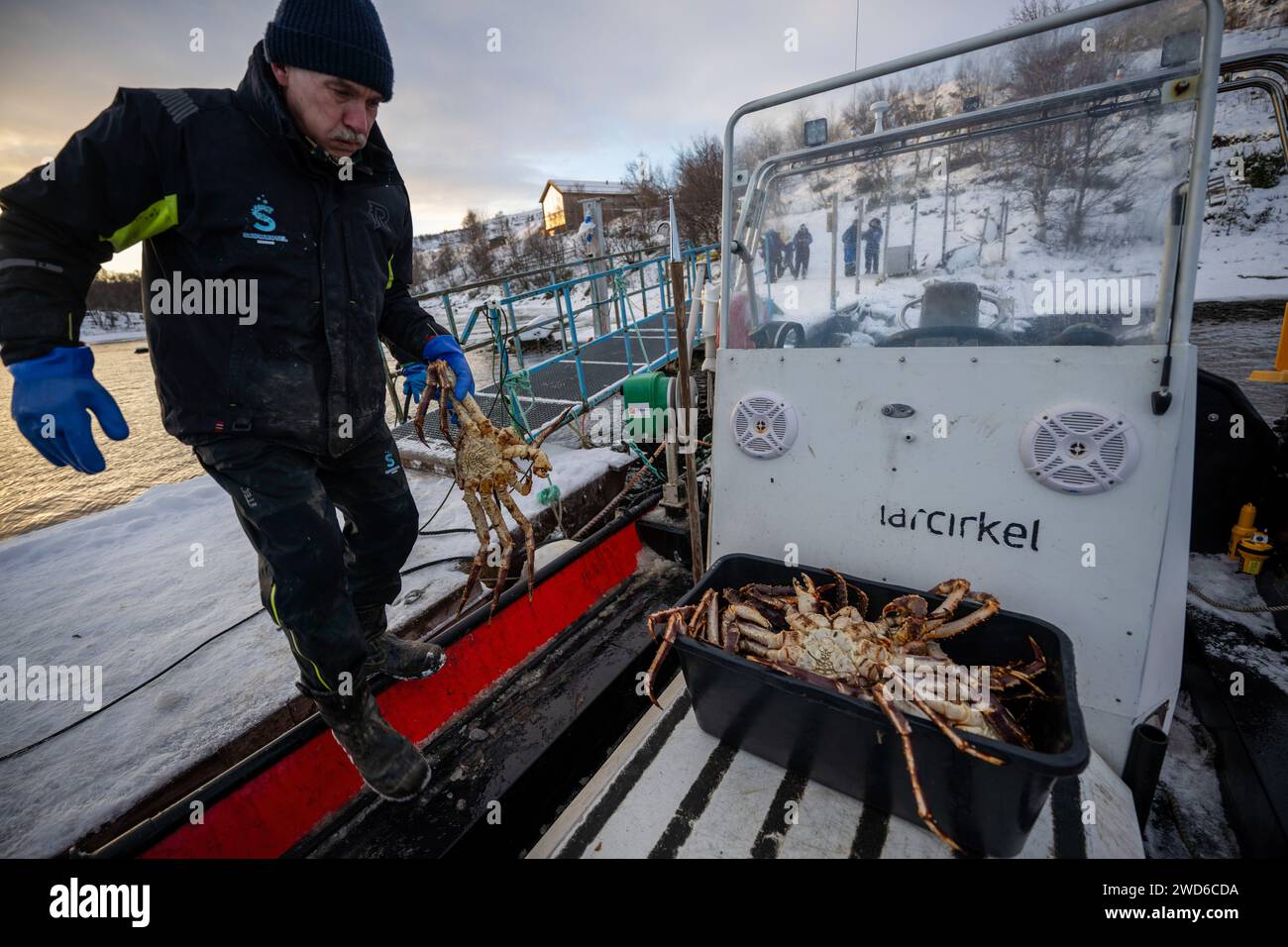 Kirkenes, Norway. 13th Jan, 2024. A fisherman handles a basket full of