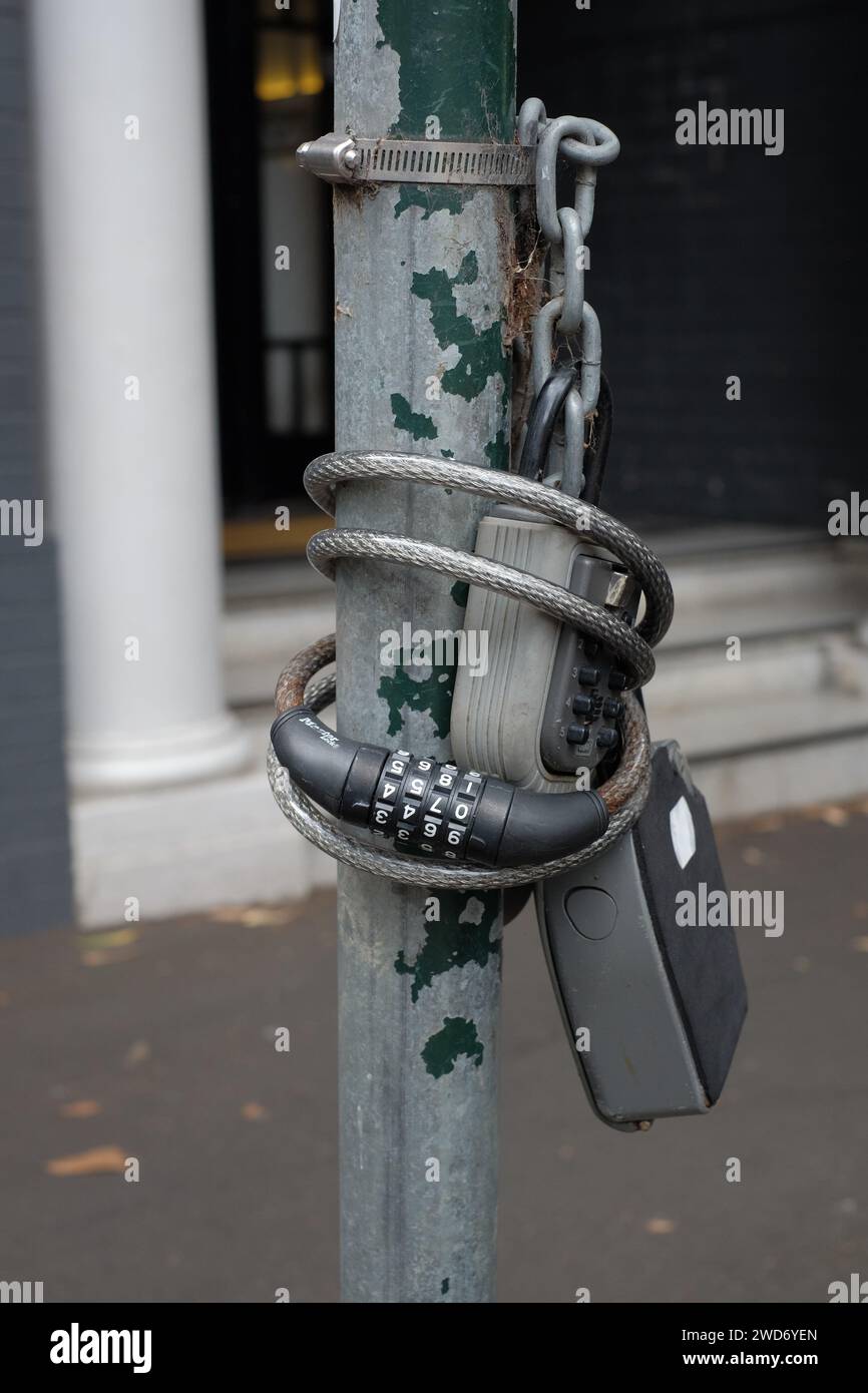 Key safe boxes strapped to a utility pole unsightly collection combination lock key boxes for AirBnb short term apartment letting in Darlinghurst Stock Photo