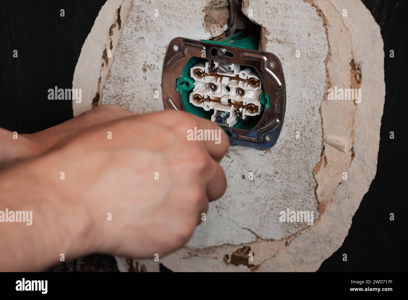 Replacing and installing a new electrical outlet. Hands with a