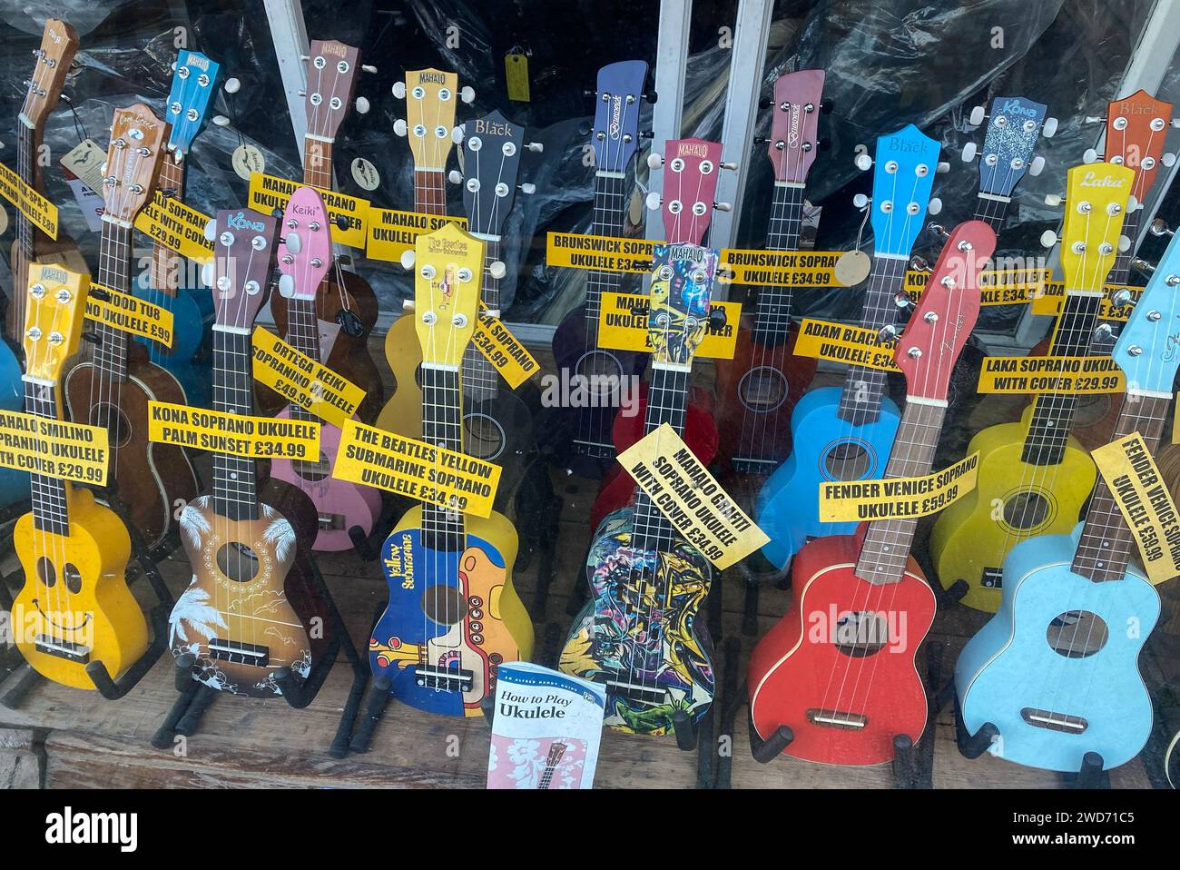 A musical instrument shop window displaying lots of Ukulele’s for sale. Stock Photo