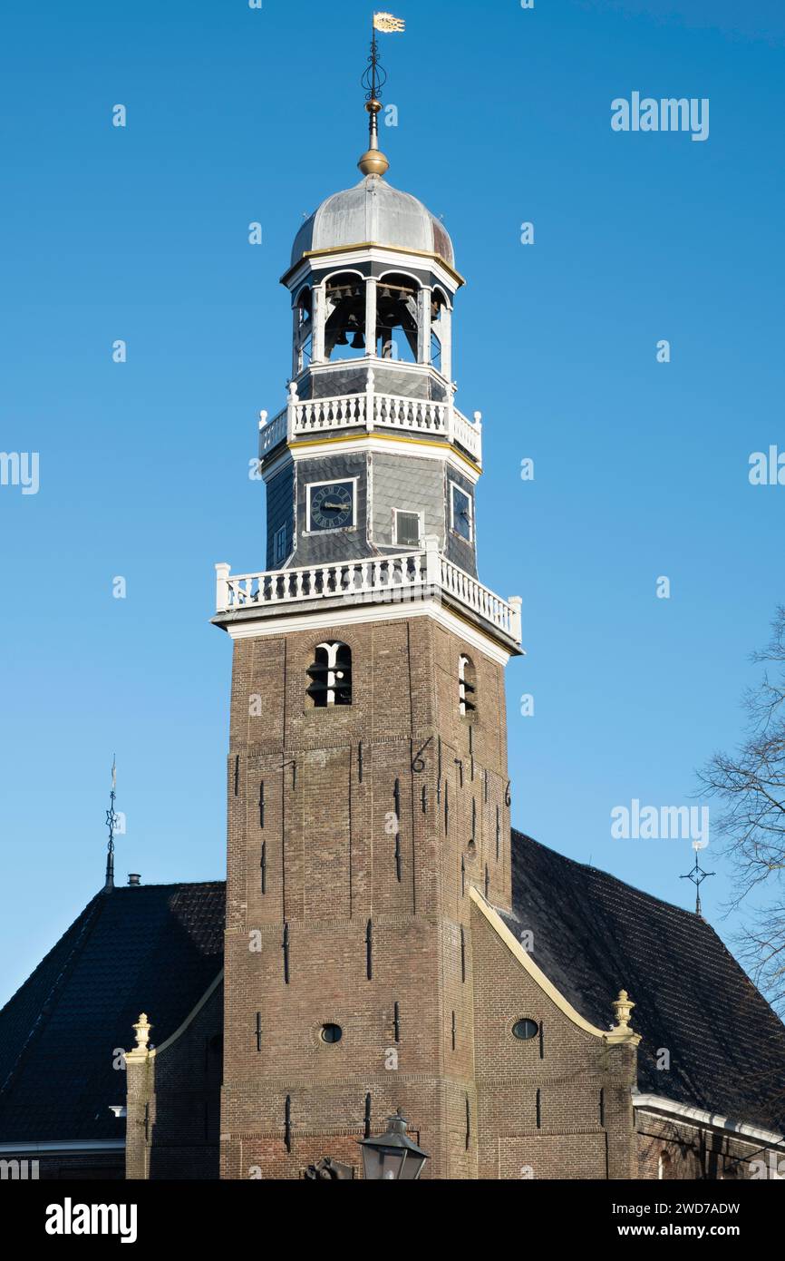 Tower of the reformed Church with an octagonal lantern, surmounted by a round domed roof and a clock in the center of the village Lemmer with blue sky Stock Photo