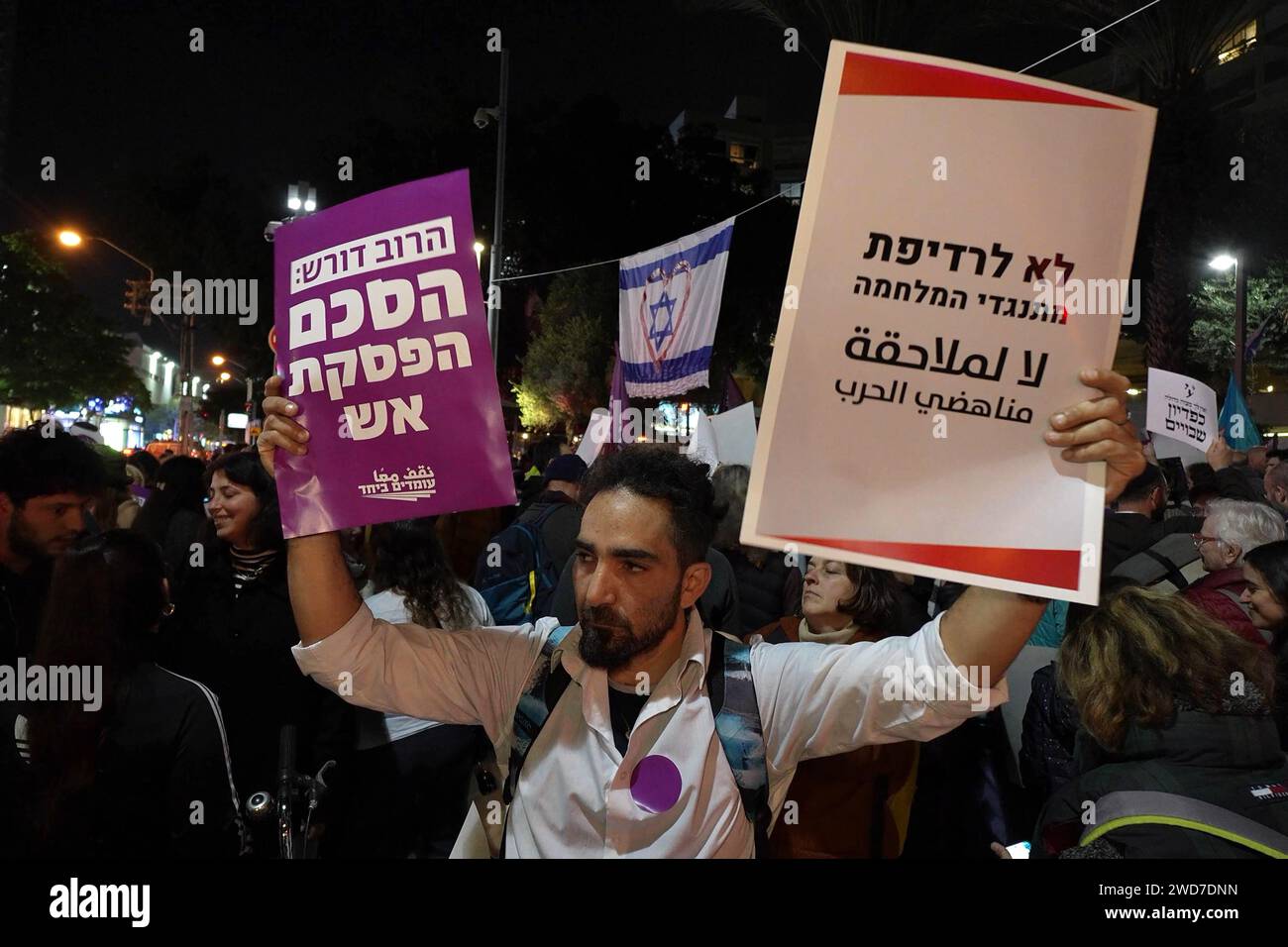 A man holds a sign that reads 'No for the persecution of opponents of the war' and 'The majority demands a ceasefire' during an anti-war protest calling for a ceasefire and diplomatic solution to the ongoing Israel-Hamas war on January 18, 2024 in Tel Aviv, Israel. Stock Photo