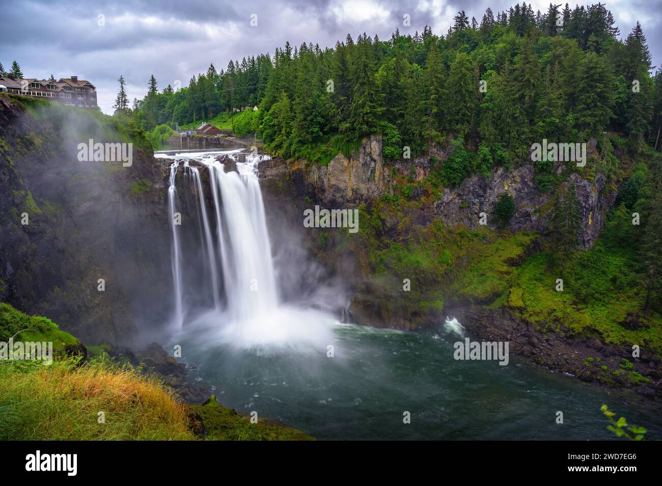 Snoqualmie Falls with lush greenery and mist in Washington State, USA Stock Photo