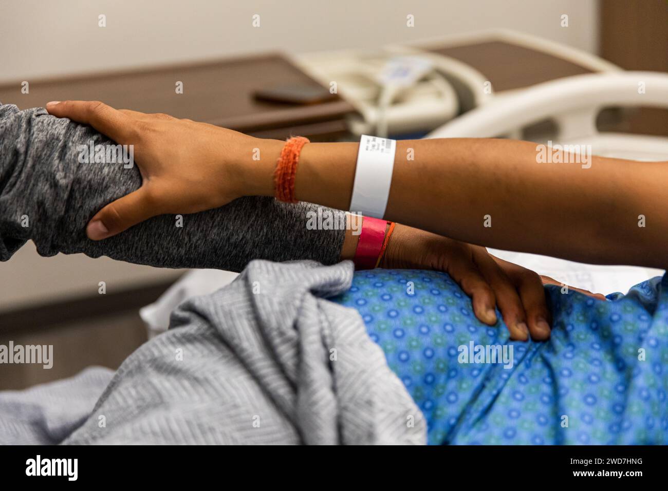 Multiracial hands in hospital bed Stock Photo
