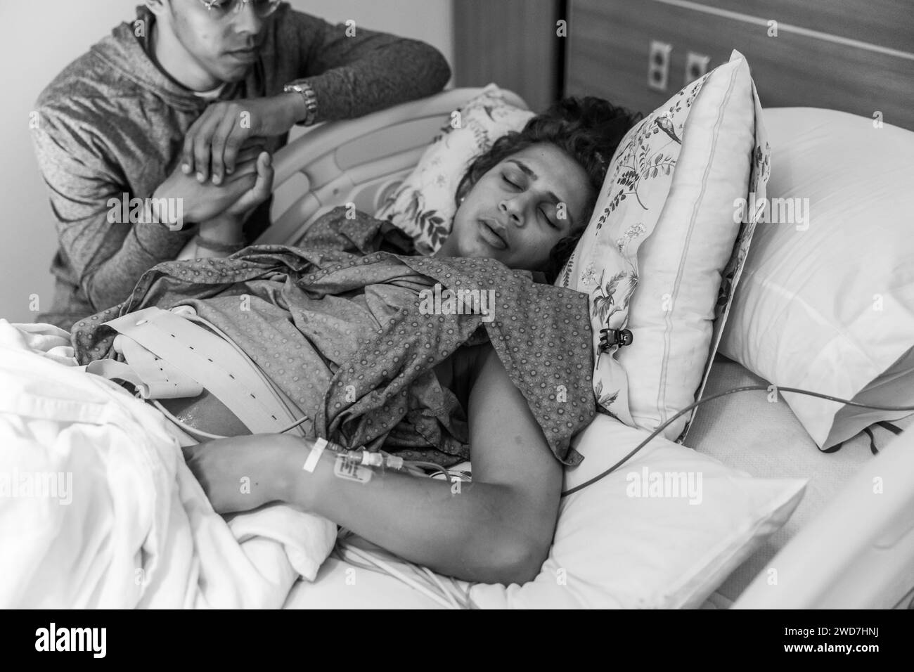Tired Indian mom closes eyes during contraction at hospital Stock Photo