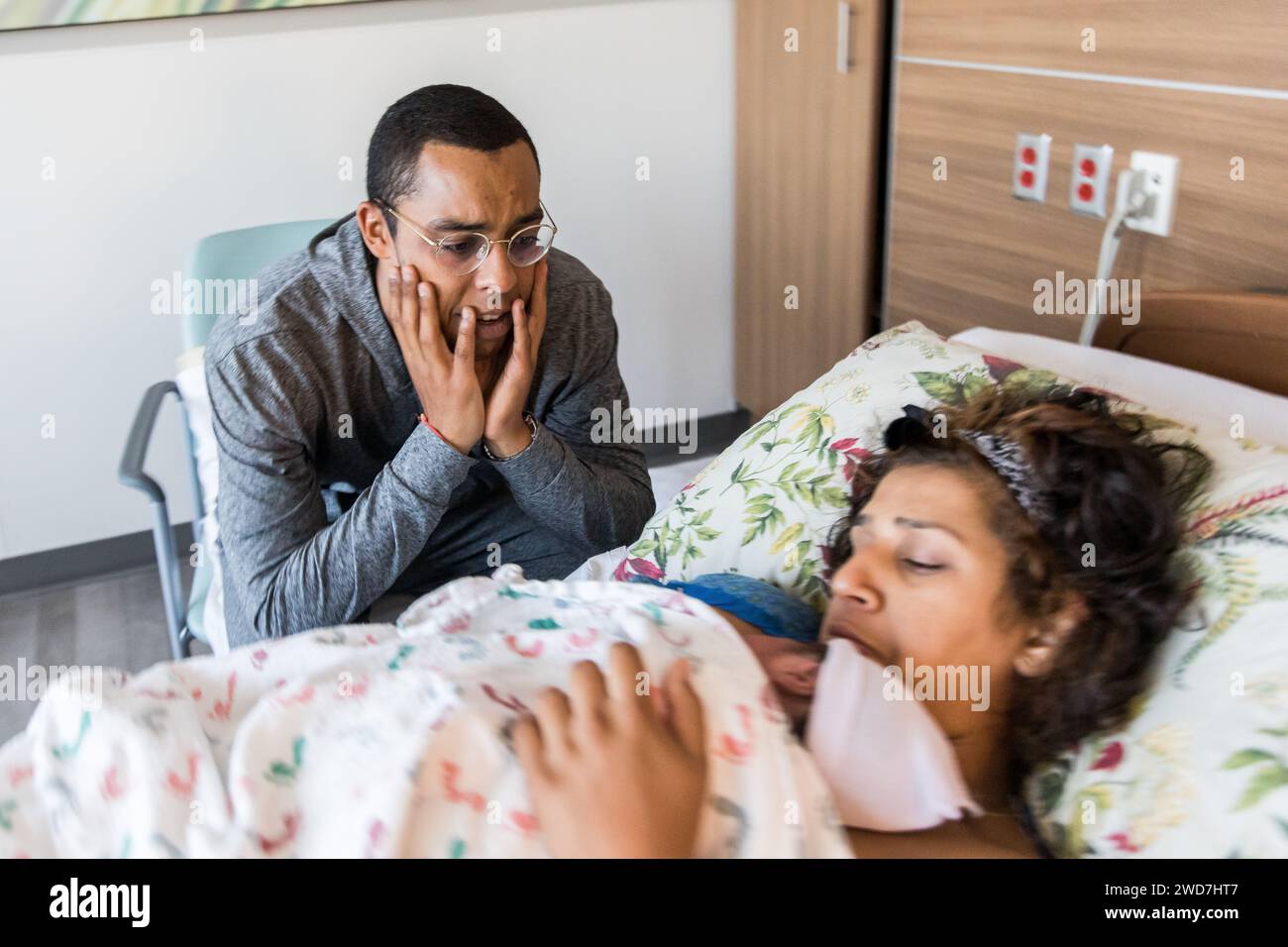 African American dad overwhelmed by emotion looking at newborn Stock Photo