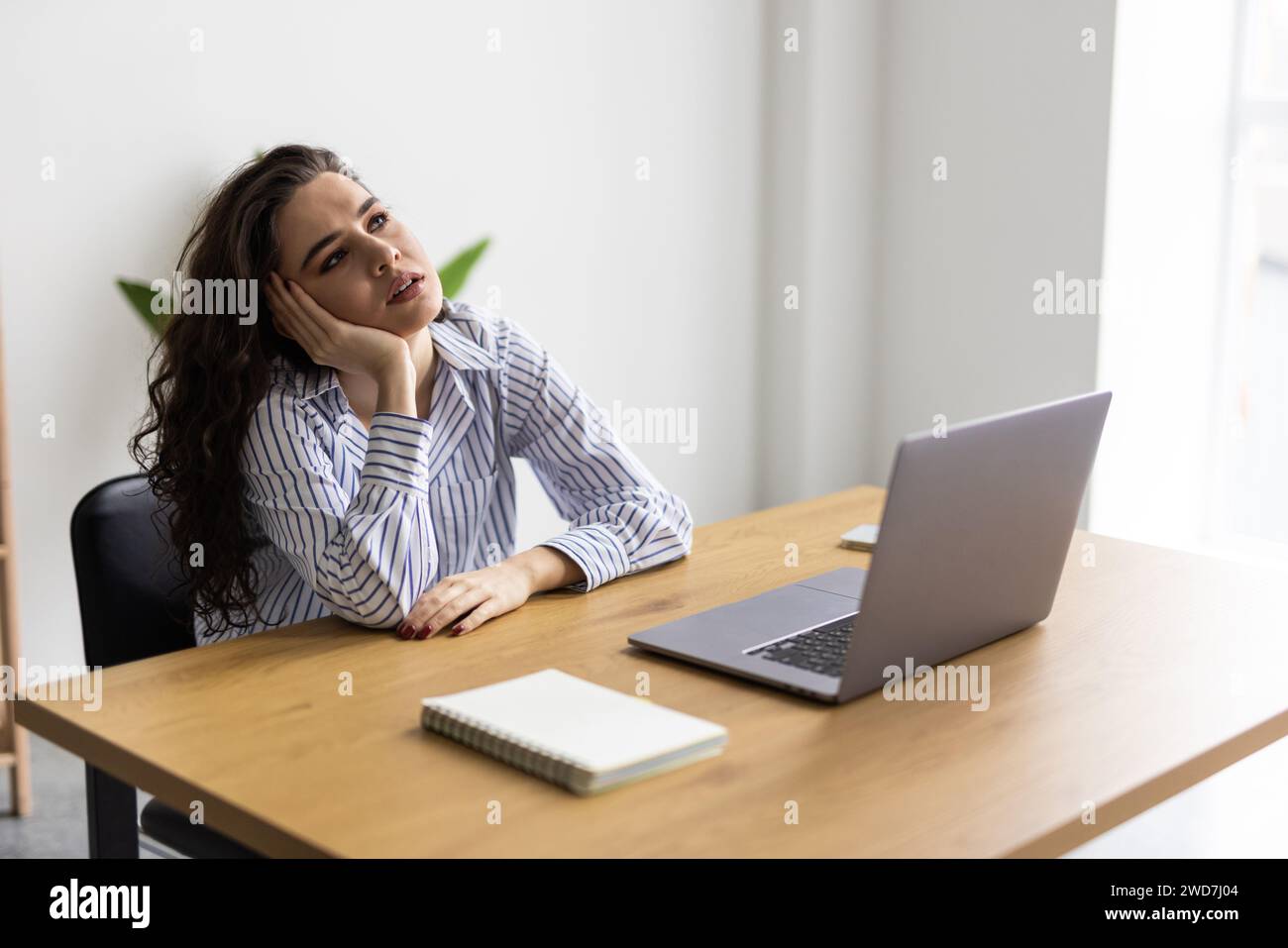Overworked and tired businesswoman sleeping over a laptop in a desk at work in her office Stock Photo